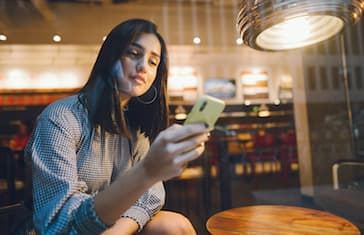 brunette girl using her cellphone to reach a friend