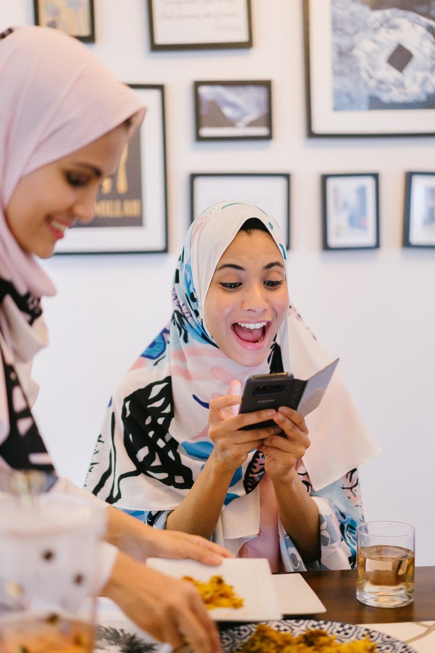Woman wearing head covering with phone